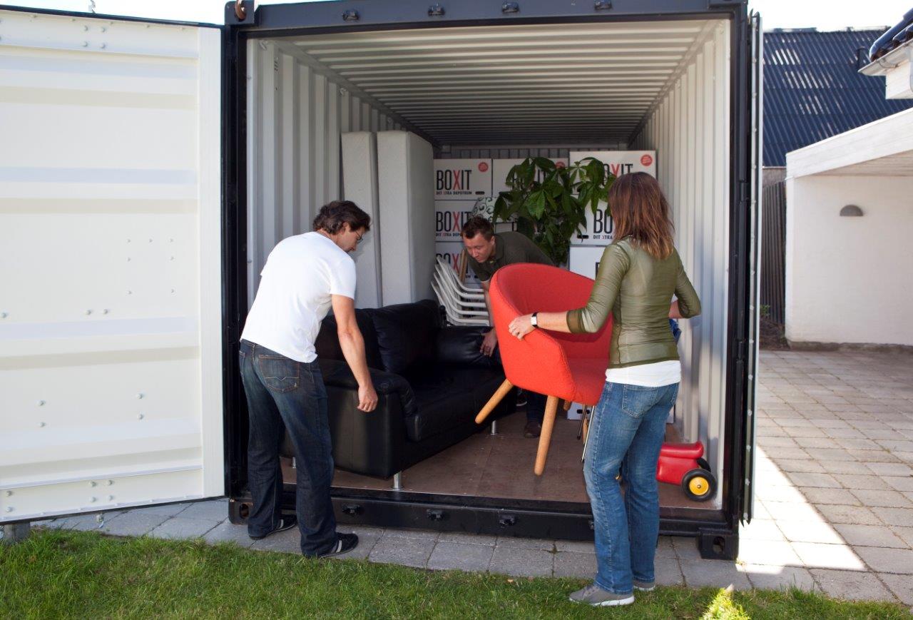 Personer packar möbler och bohag i en flyttcontainer från BOXIT